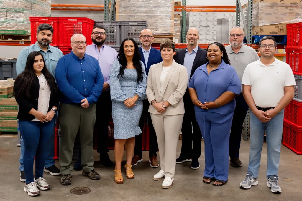 Choice Kitchen team members posing together inside a warehouse facility.